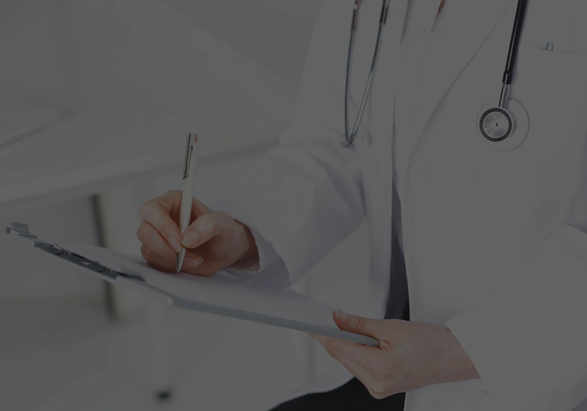 A healthcare professional writing on a clipboard. Agentic AI transforms this type of unstructured free text into homogeneous and traceable clinical data. 